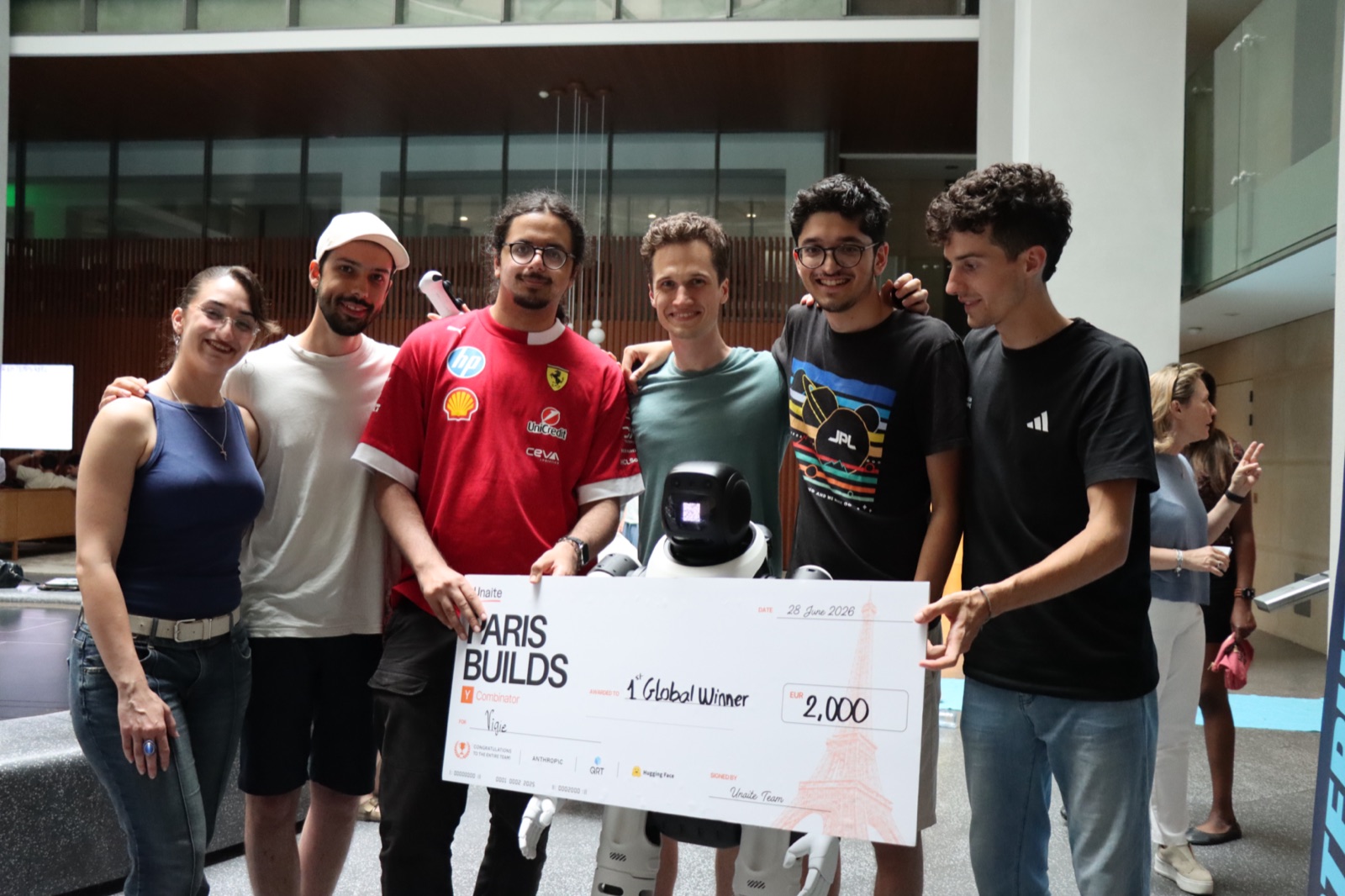 The Vigie team holding the 1st Global Winner check at the YC Paris × Unaite Hackathon (Paris Builds), 28 June 2026